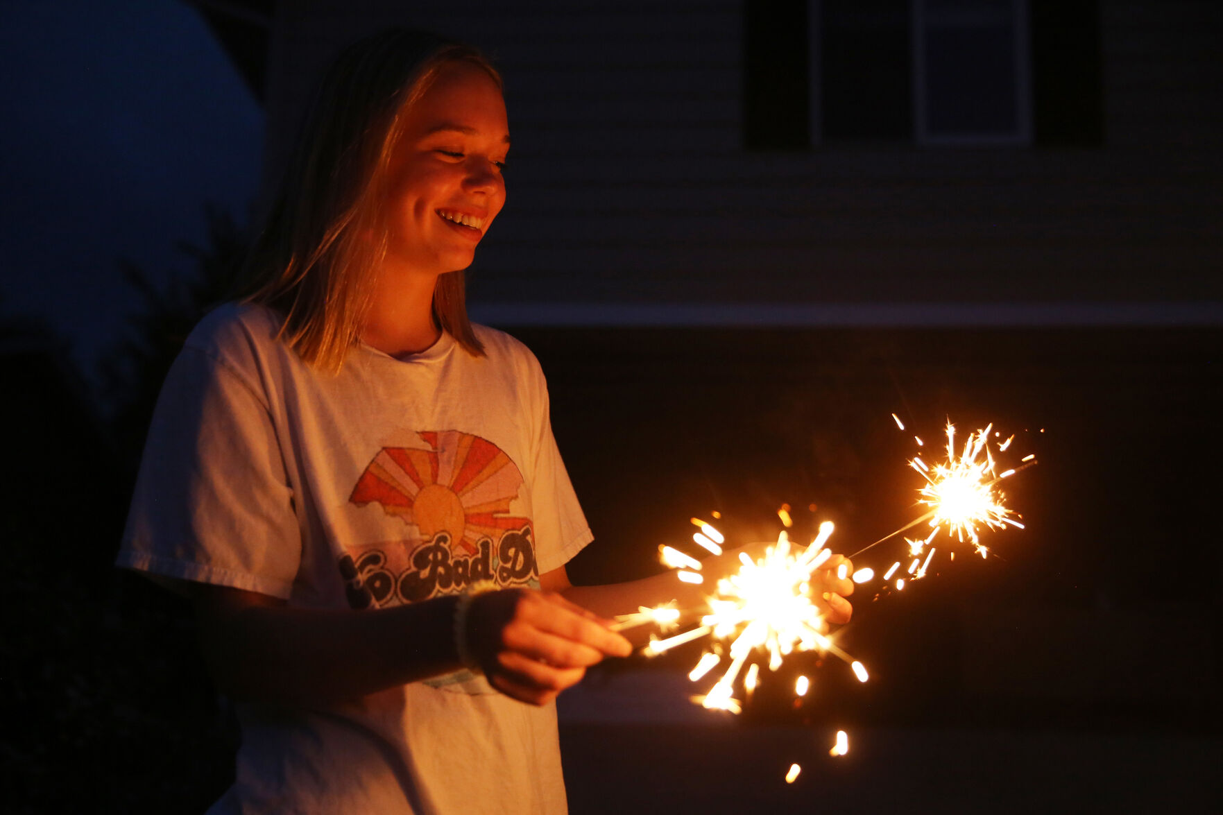 Bella Johnson, 17, laughs as her two sparklers